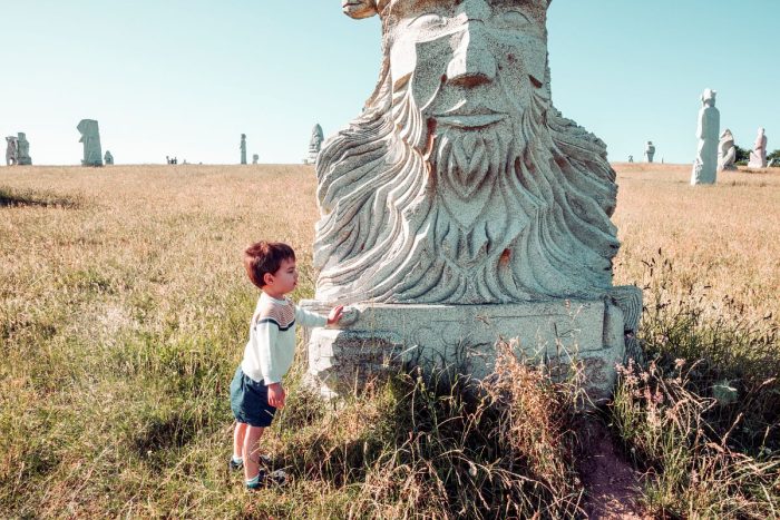 Un enfant devant une statue à la Vallée des Saints